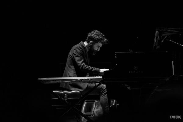 Antonio tocando un piano de cola Yamaha en un escenario, en blanco y negro
